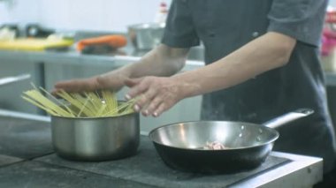 Restoranın mutfakta aşçı makarna carbonara hazırlar