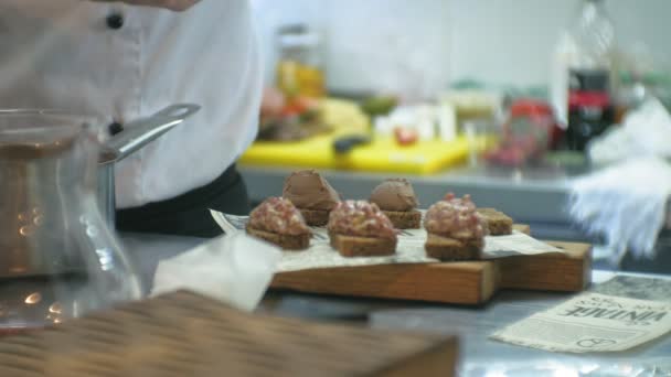 Повар на кухне ресторана готовит мясные закуски — стоковое видео