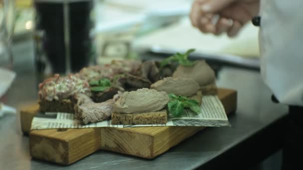 O cozinheiro na cozinha do restaurante prepara lanches de carne — Vídeo de Stock