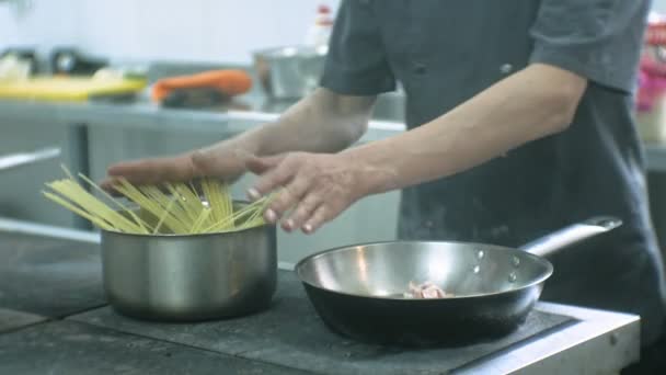 Повар на кухне ресторана готовит пасту карбонара — стоковое видео