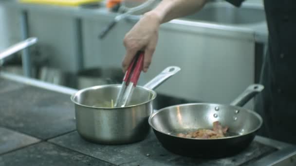 Kuchař v kuchyni restaurace připraví těstoviny carbonara — Stock video