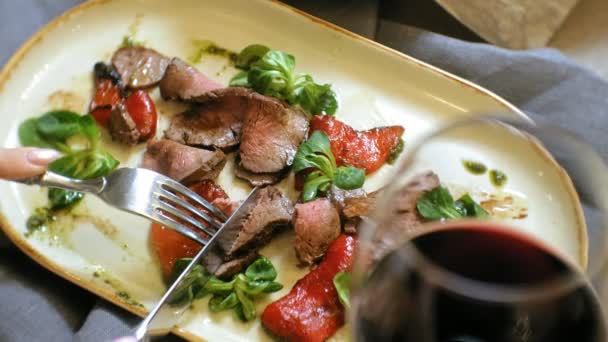 Tiro de perto: um prato de carne saboroso em uma chapa, carne de vaca assada com pimentas doces e folhas de salada verdes . — Vídeo de Stock