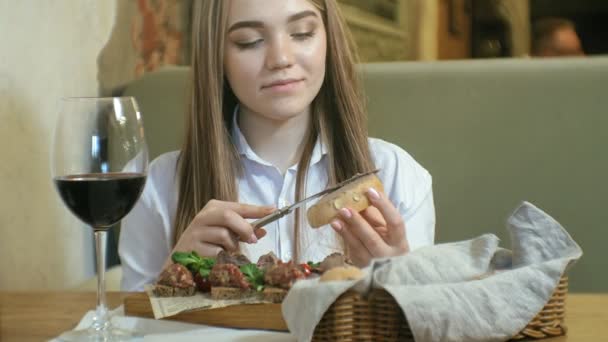 Hermosa mujer rubia comiendo y bebiendo en el restaurante, hora del almuerzo — Vídeos de Stock