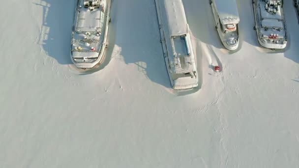 Duże Statki rzeczne na parkingu zimowym. Statki są zamrożone w lodzie. Filmowanie lotnicze — Wideo stockowe