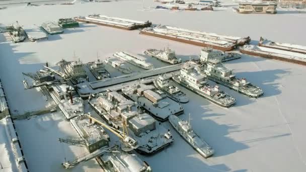 Великі річкові кораблі на зимовому паркінгу. Кораблі заморожені в льоду. Повітряні зйомки — стокове відео
