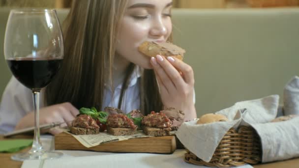 Hermosa mujer rubia comiendo y bebiendo en el restaurante, hora del almuerzo — Vídeos de Stock