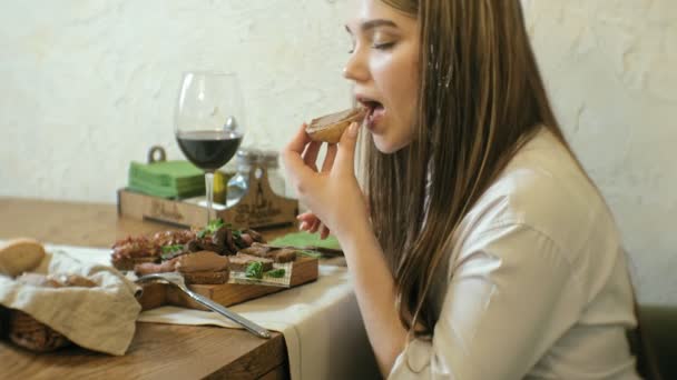 Schöne blonde Frau isst und trinkt im Restaurant, Mittagspause — Stockvideo