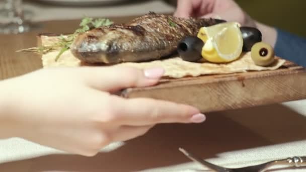 Tiro de cerca: dorylo pescado a la parrilla con aceitunas y una rebanada de limón en pan de pita . — Vídeos de Stock