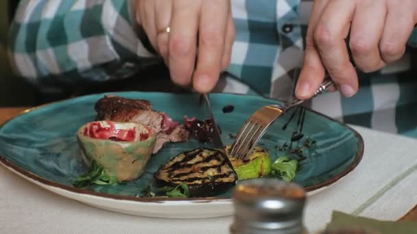 Съемка крупным планом: запечённое мясо и овощи на гриле с красным соусом на голубой тарелке — стоковое видео