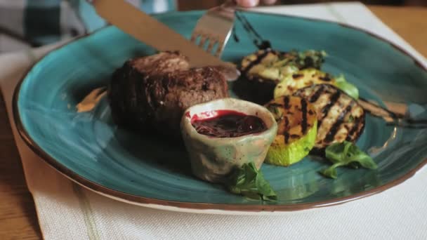 Съемка крупным планом: запечённое мясо и овощи на гриле с красным соусом на голубой тарелке — стоковое видео
