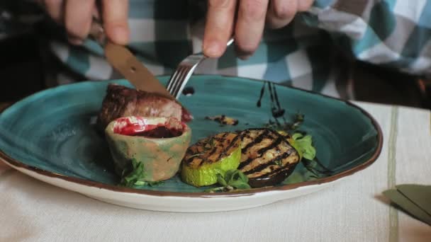Yakın çekim çekim: pişmiş et ve mavi bir plaka üzerinde kırmızı soslu ızgara sebze — Stok video