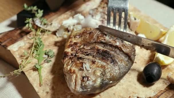 Close-up schieten: gegrilde vis dorylo met olijven en een schijfje citroen op pita brood. — Stockvideo