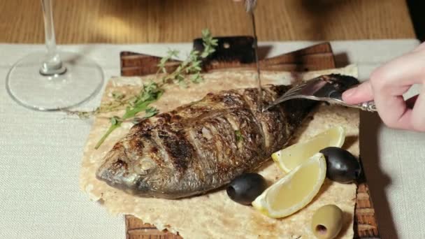 Close-up schieten: gegrilde vis dorylo met olijven en een schijfje citroen op pita brood. — Stockvideo