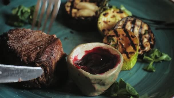 근접 촬영: 구운 고기 및 파란색 접시에 빨간 소스와 구운된 야채 — 비디오