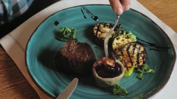 Gros plan : viande cuite au four et légumes grillés avec sauce rouge sur une assiette bleue — Video