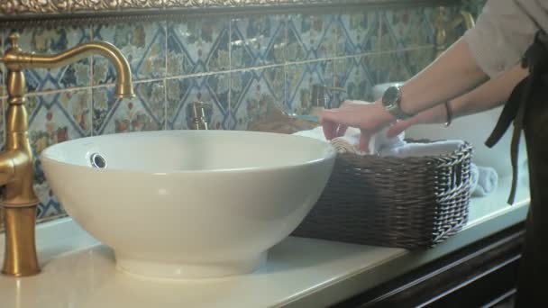 Frau faltet saubere weiche Handtücher in den Korb, Reinigungskonzept — Stockvideo