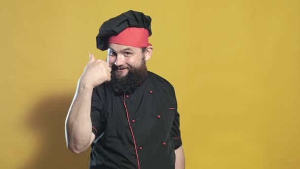 Cuocere in un abito nero su uno sfondo giallo — Video Stock