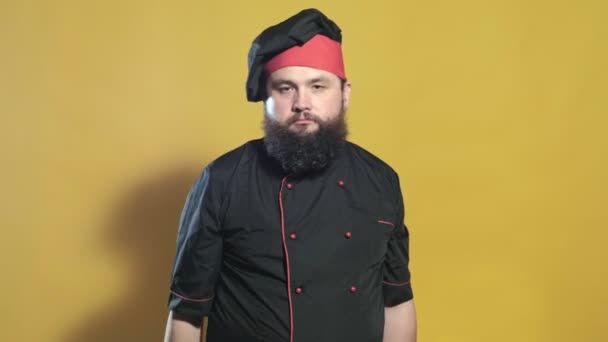 Cuocere in un abito nero su uno sfondo giallo — Video Stock