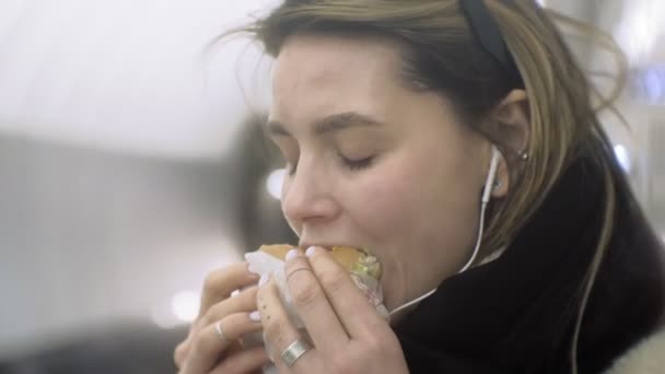 Vrouw eten Fast Food in de metro — Stockvideo