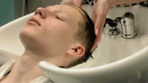 美容師はサロンで頭の少年を洗う — ストック動画