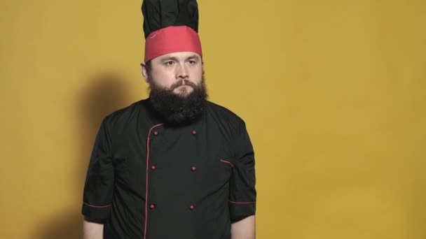 Cozinhe em um terno preto em um fundo amarelo — Vídeo de Stock