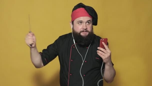 Cozinhe em um terno preto em um fundo amarelo — Vídeo de Stock