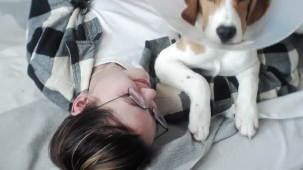 Mujer jugando con un perro en la cama — Vídeo de stock