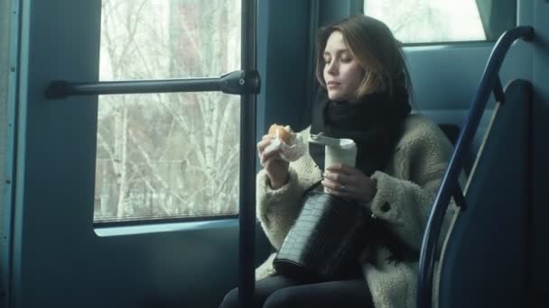 Junge brünette Frau fährt mit öffentlichen Verkehrsmitteln, benutzt das Telefon mit Kopfhörern — Stockvideo