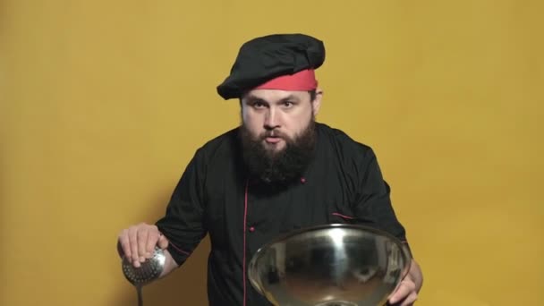 黄色の背景に黒のスーツを着て料理する — ストック動画