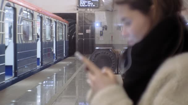 Mulher está esperando por um trem no metrô — Vídeo de Stock