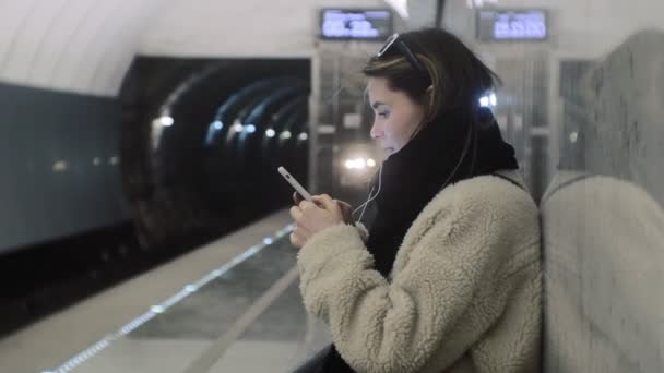 Vrouw wacht op een trein in de metro — Stockvideo