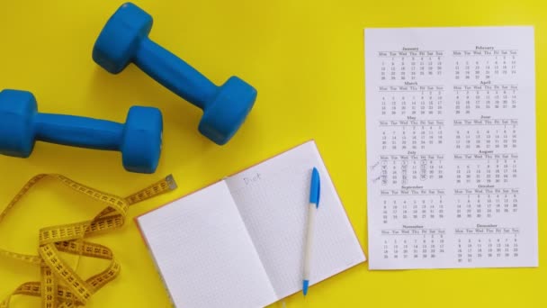 Sports calendar, healthy food, shooting on a yellow background top view — Stock Video