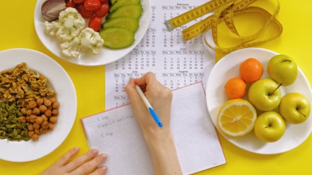 Calendário de esportes, comida saudável, tiro em um fundo amarelo vista superior — Vídeo de Stock