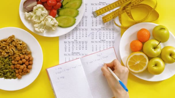 Calendário de esportes, comida saudável, tiro em um fundo amarelo vista superior — Vídeo de Stock