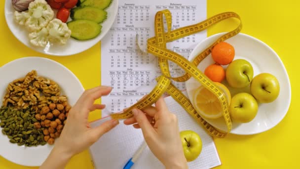 Спортивный календарь, здоровое питание, съемка на желтом фоне вид сверху — стоковое видео