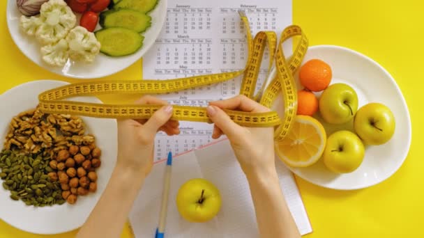 Спортивный календарь, здоровое питание, съемка на желтом фоне вид сверху — стоковое видео