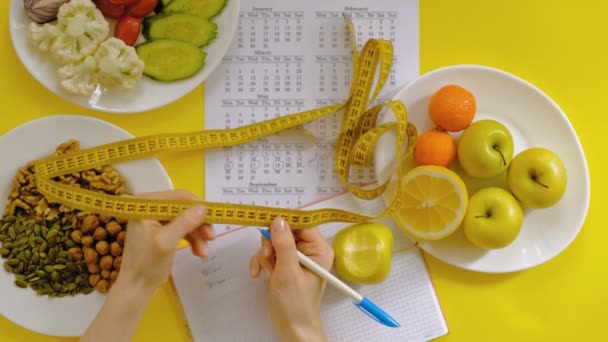 Sportkalender, hälsosam mat, skytte på en gul bakgrund uppifrån — Stockvideo