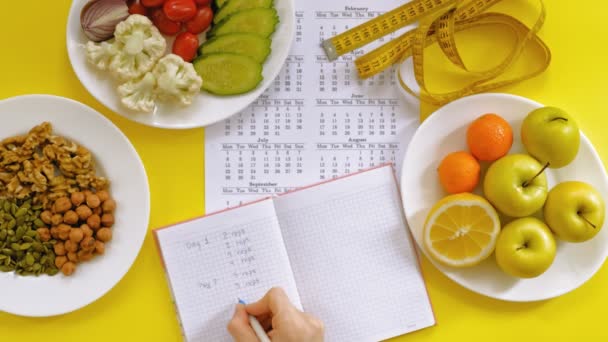 Sportovní kalendář, zdravé jídlo, fotografování na žlutém pohledu na pozadí — Stock video