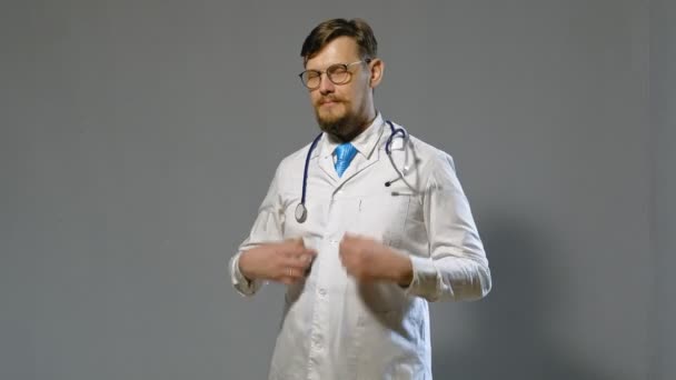 Doctor man in witte vacht op grijze achtergrond, geneeskunde concept — Stockvideo