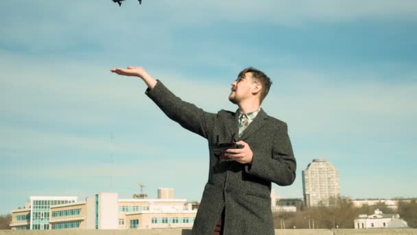 Человек управляет квадрокоптером на открытом воздухе — стоковое видео