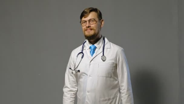 Doctor hombre en bata blanca sobre fondo gris, concepto de medicina — Vídeos de Stock