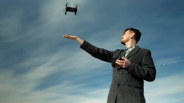 Hombre controla quadcopter al aire libre — Vídeos de Stock