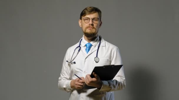 Doctor man in witte vacht op grijze achtergrond, geneeskunde concept — Stockvideo