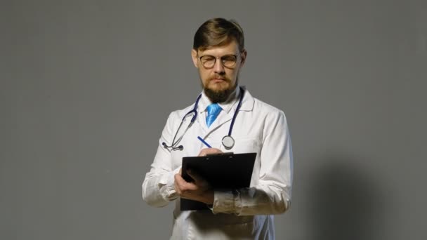 Doctor man in witte vacht op grijze achtergrond, geneeskunde concept — Stockvideo