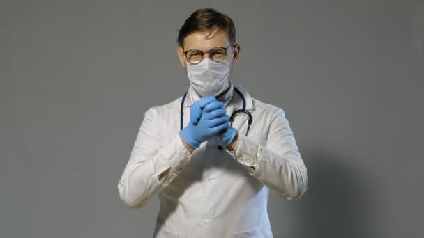 Férfi orvos fehér kabátot szürke háttér, gyógyszer koncepció — Stock videók