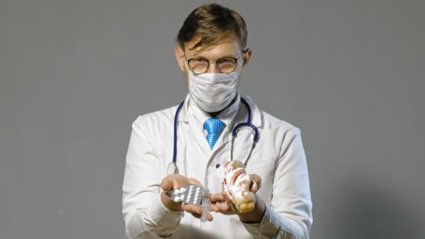 Doctor hombre en bata blanca sobre fondo gris, concepto de medicina — Vídeos de Stock