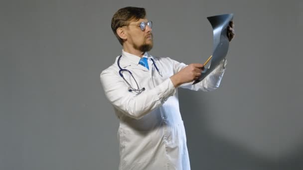 Médico homem de casaco branco em fundo cinza, conceito de medicina — Vídeo de Stock