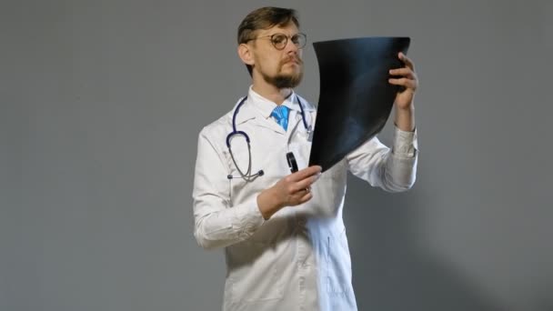 Врач в белом халате на сером фоне, концепция медицины — стоковое видео