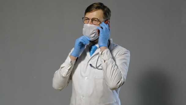 Docteur homme en manteau blanc sur fond gris, concept de médecine — Video