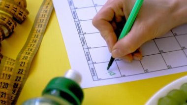 Sağlıklı gıda, diyet, üst görünüm, sarı arka plan kavramı bir fitness takvimi tutmak